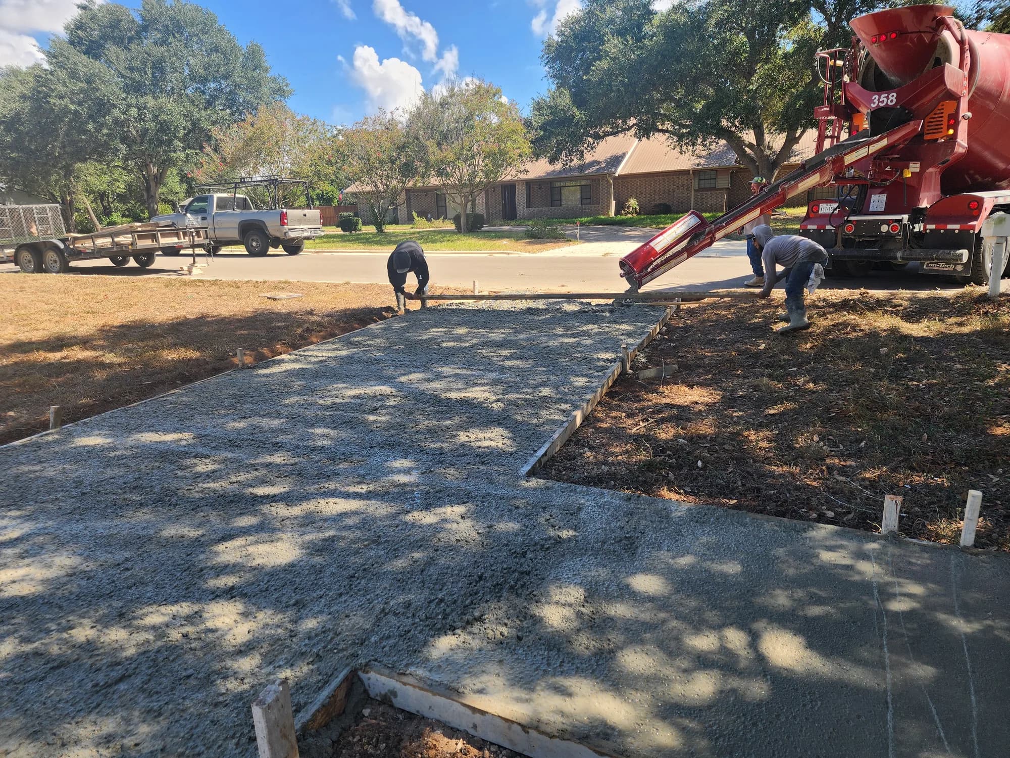 Concrete crew placing and leveling a residential slab in San Antonio