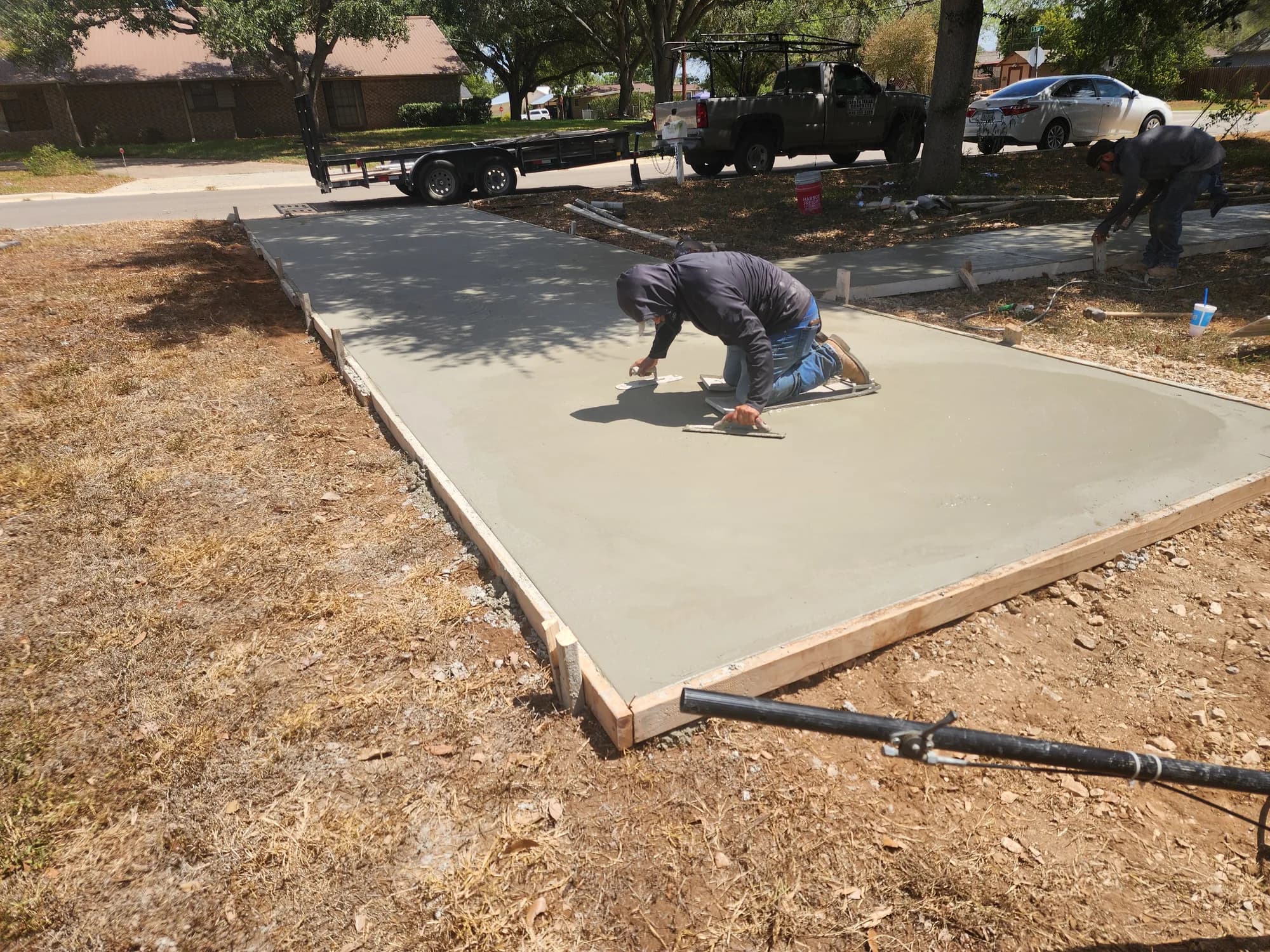 Concrete finisher smoothing a newly poured residential concrete surface