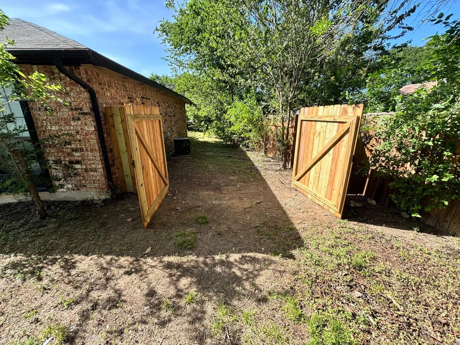 Completed double wood fence gates providing backyard access