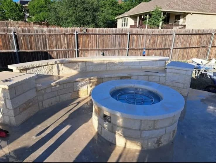 Stone fire pit and curved masonry seating wall in Greater San Antonio